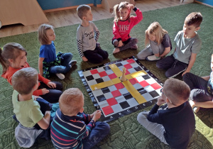 dzieci oglądają zasięg hetmana na szachownicy